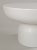 Stolik kawowy MARUMI pokryty mikrocementem w kolorze signal hydro white czyli w kolorze neutralnej bieli. Blat okrągły zaoblony od spodu, noga kształtem przypominająca półkulę. Naturalna struktura, matowe wykończenie.